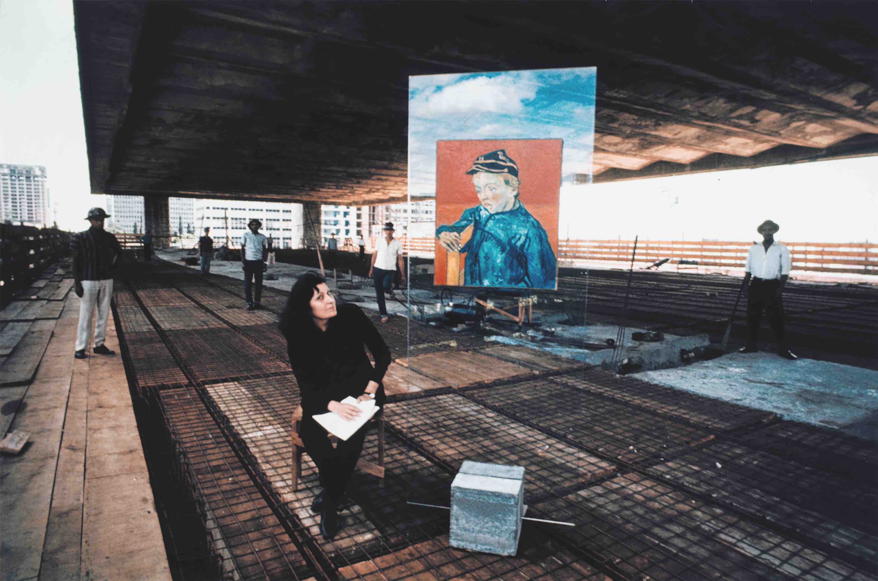 Lina Bo Bardi en la construcción del MASP en Avenida Paulista junto al prototipo del caballete de vidrio con la reproducción de El estudiante de Vincent van Gogh en 1967. Colección Instituto Bardi / Casa de Vidro São Paulo. Fotografía: Lew Parrella
